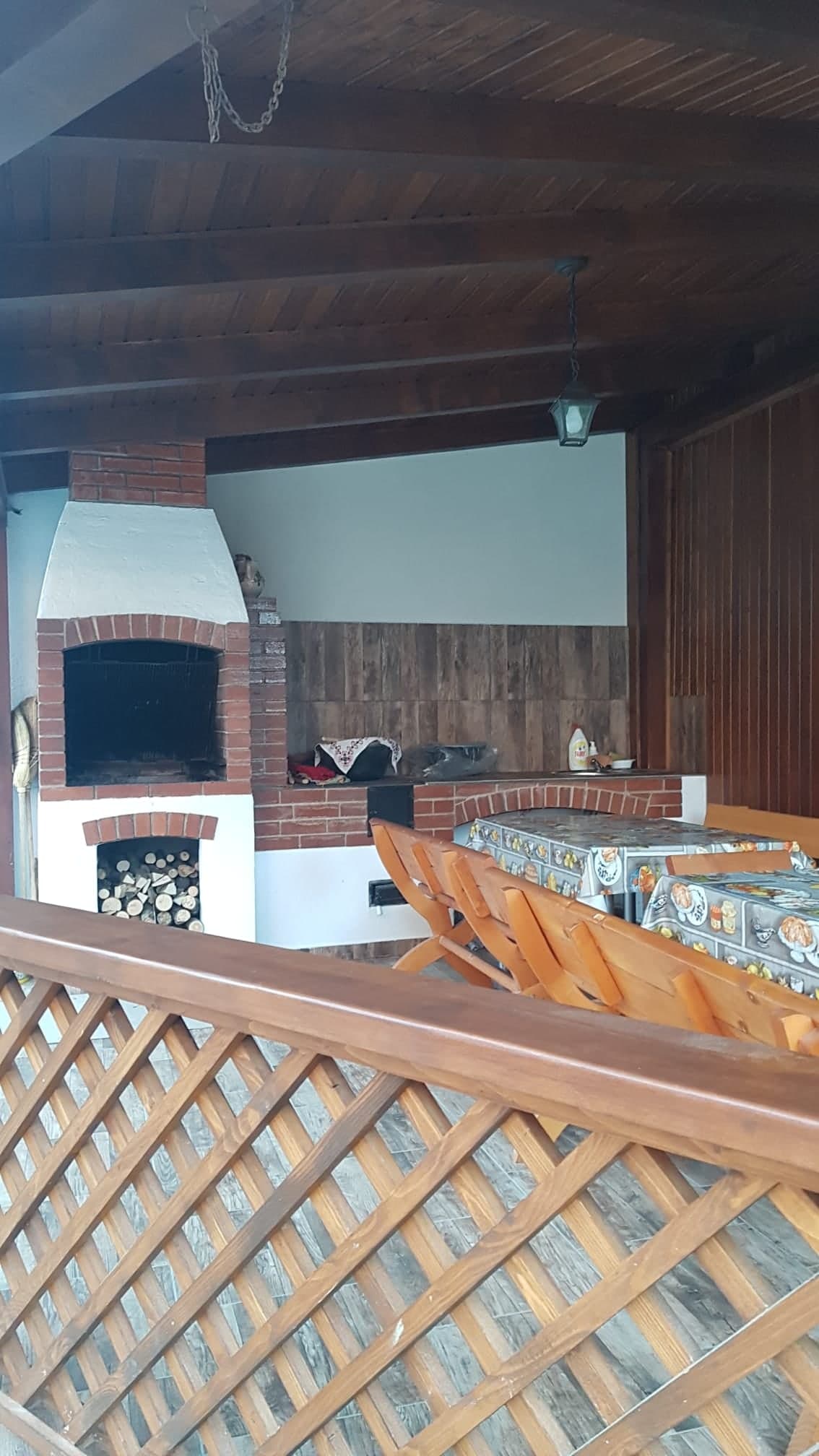 Interiorul foișorului: grătar din cărămidă, lemne și masă
